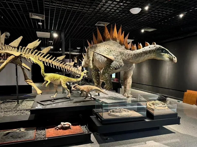 Life-size animatronic dinosaur exhibit in a natural history museum gallery